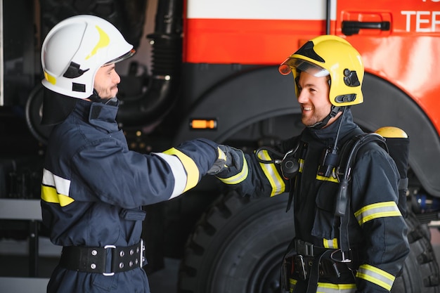Retrato de dos heroicos bomberos con traje protector y casco