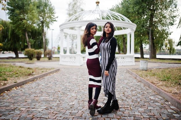 Retrato de dos jóvenes hermosas adolescentes indias o del sur de Asia vestidas con un arco de templo blanco de fondo