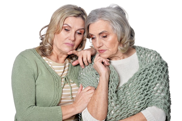 Retrato de dos mujeres tristes sobre fondo blanco.