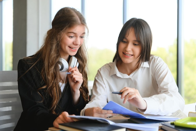 Retrato de dos niñas en el lugar de trabajo con libros Educación escolar