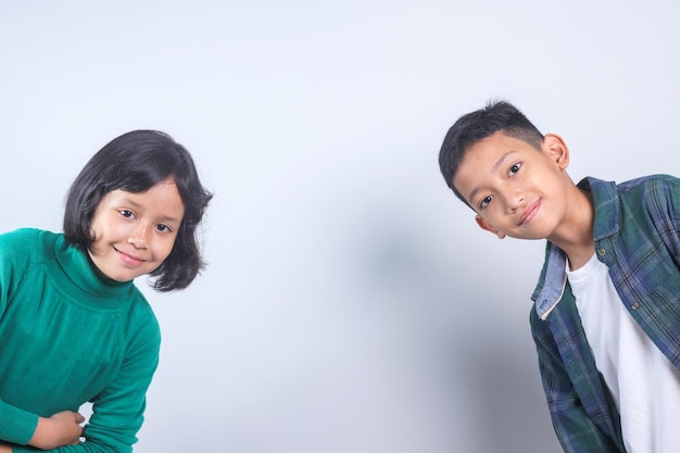 Retrato de dos niños asiáticos alegres con espacio de copia en fondo gris