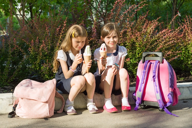 Foto retrato de dos novias colegialas comiendo helado