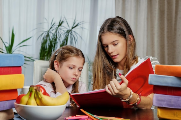 Retrato de dos novias estudiando en la mesa con muchos libros.