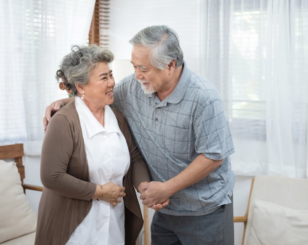 Retrato dos pares asiáticos sênior idosos felizes junto em casa.