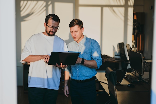 Retrato de dos programadores masculinos profesionales que trabajan en computadoras en diversas oficinas Tecnologías informáticas modernas Desarrollo de aplicaciones de programas de inteligencia artificial y concepto de videojuegos