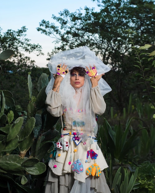 Foto retrato de una drag queen en un paisaje rural persona de género no binario que interactúa con la naturaleza