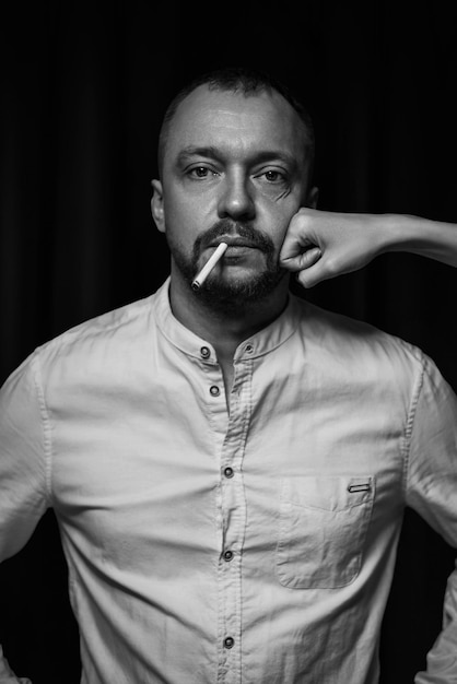Retrato dramático de un hombre adulto con un cigarrillo en la boca Fotografía de estudio