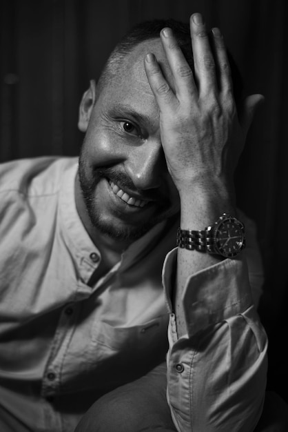 Foto retrato dramático de un hombre adulto sonriente fotografía de estudio imagen en blanco y negro