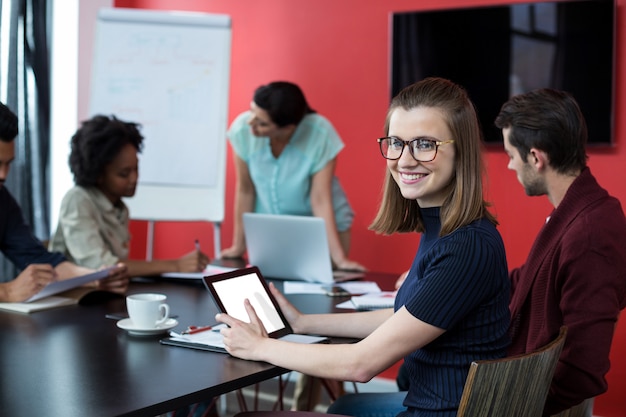 Retrato de ejecutivo de negocios con tableta digital y colega trabajando