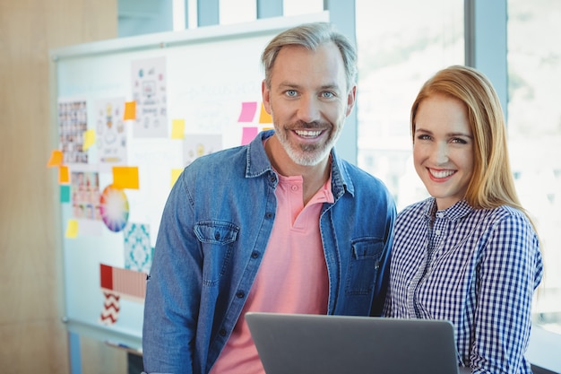 Retrato de ejecutivos de negocios masculinos y femeninos con laptop