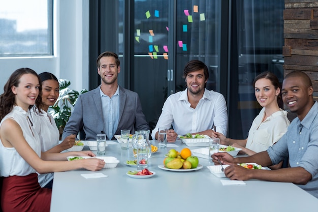 Retrato de ejecutivos de negocios que tienen comida en la oficina