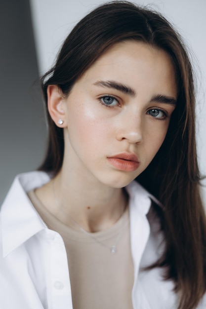 Retrato elegante de uma jovem modelo de 15 anos com luz natural em um espaçoso estúdio fotográfico