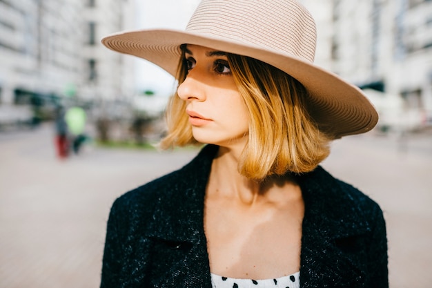 Retrato de elegante elegante mujer rubia de pelo corto con sombrero posando