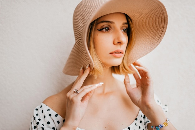 Retrato de elegante elegante vestido y sombrero de womanin rubia de pelo corto