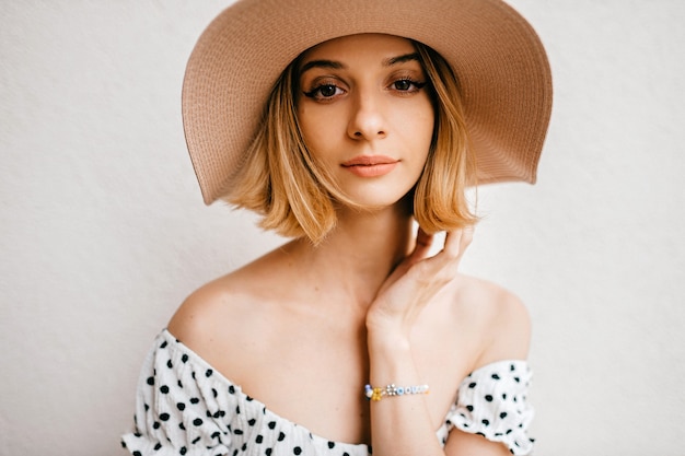 Retrato de elegante elegante vestido y sombrero de womanin rubia de pelo corto