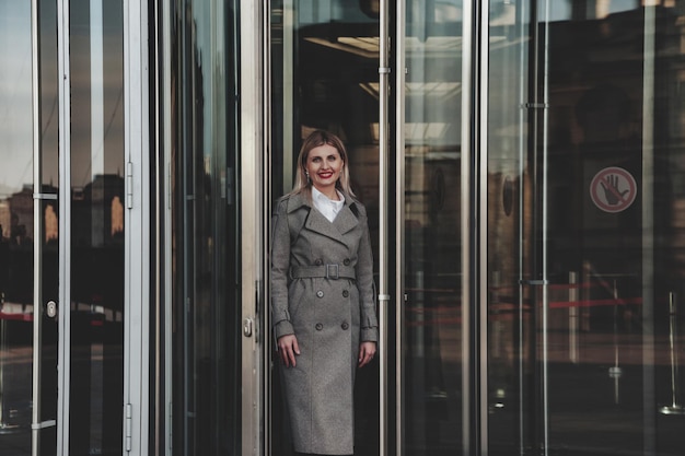 Retrato elegante empresária ao ar livre no contexto do distrito empresarial. Mulher de negócios em roupas casuais na cidade financeira. Fêmea muito sorridente em roupas de estilo no prédio. Copiar espaço