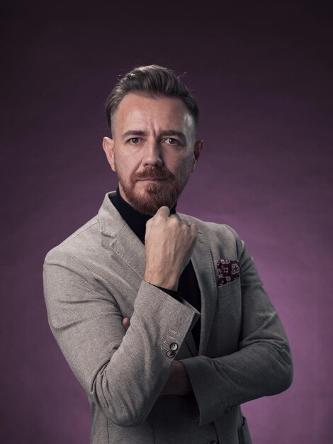 Retrato de un elegante hombre de negocios de alto nivel con barba y ropa informal de negocios en un estudio fotográfico aislado en un fondo oscuro gesticulando con las manos. foto de alta calidad