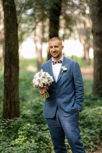 Retrato de un elegante novio con traje azul.