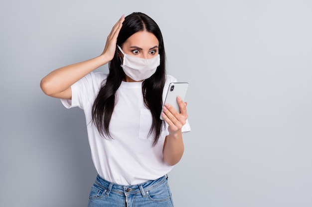 Retrato de ella, bonita, atractiva, preocupada, chica de pelo recto usando un dispositivo de lectura de malas noticias falsas, orden de contaminación mundial aislado sobre fondo de color gris claro