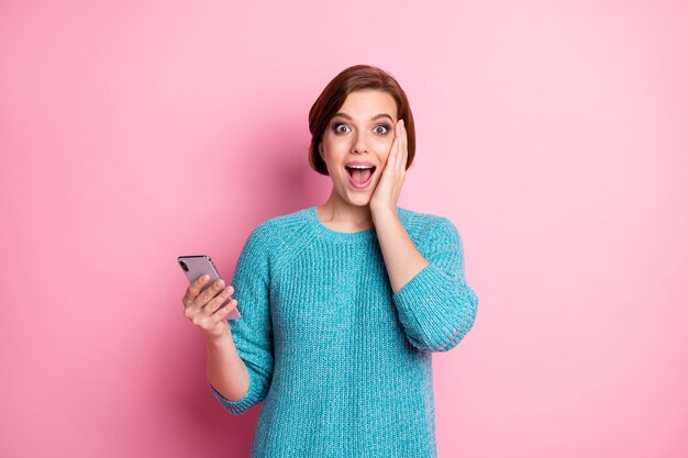 Retrato de ella ella agradable atractivo encantador contento emocionado alegre alegre chica de cabello castaño sosteniendo en la mano celda genial buenas noticias