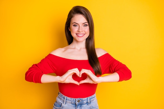 Foto retrato de ella ella agradable atractivo encantador encantador alegre alegre chica de pelo castaño mostrando paz en forma de corazón aislado brillante vivo brillo vibrante fondo de color amarillo