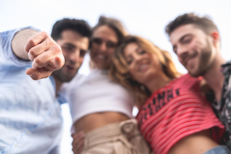 Foto retrato em baixo ângulo de amigos de pé contra o céu
