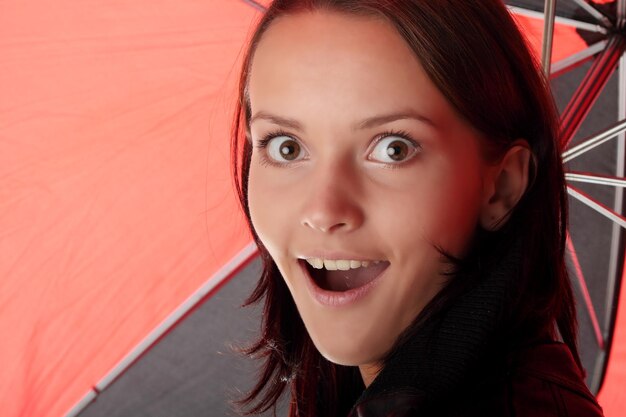 Foto retrato em close-up de jovem chocada com guarda-chuva