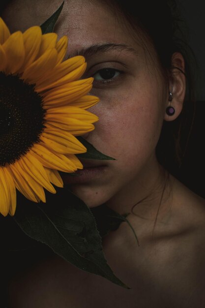 Retrato em close-up de jovem com girassol