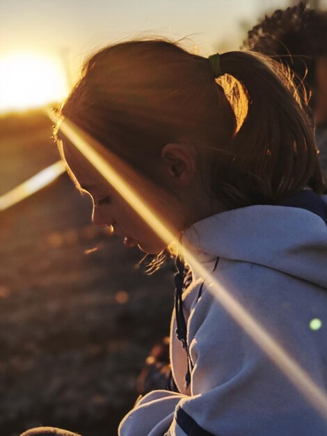 Foto retrato em close-up de mulher contra o céu durante o pôr-do-sol