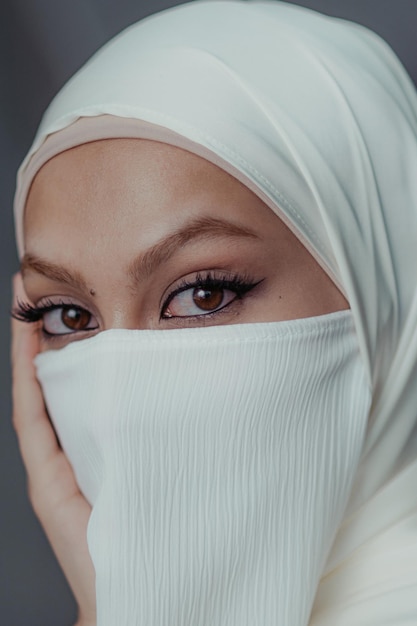 Retrato em close-up de mulher muçulmana velada com hijab branco de ângulo alto