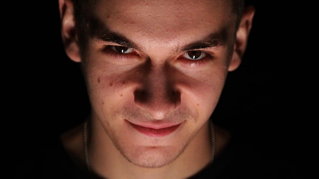 Retrato em close-up de um homem adulto em meio a um fundo preto