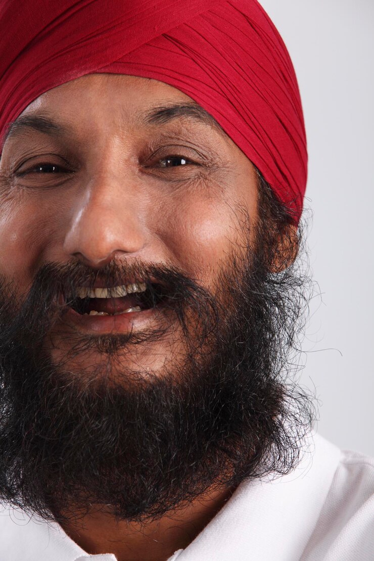 Foto retrato em close-up de um homem barbudo vestindo um turbante vermelho