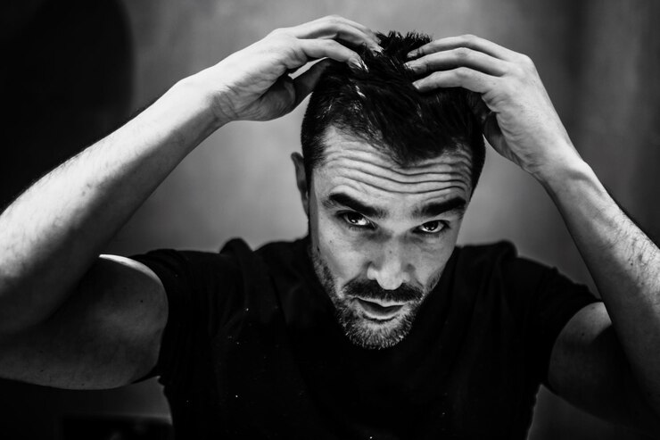 Foto retrato em close-up de um homem com a mão no cabelo