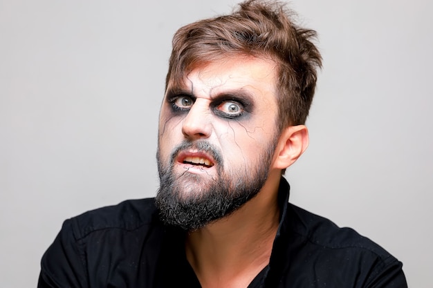 Retrato em close-up de um homem com barba com maquiagem para o Halloween no estilo dos mortos-vivos