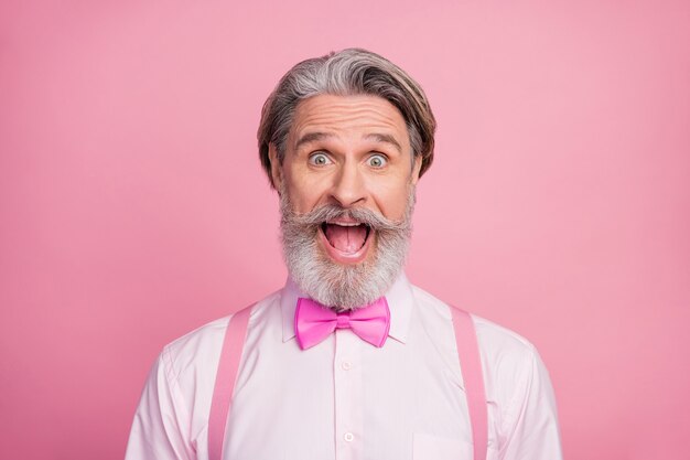 Foto retrato em close-up de um homem louco e extasiado de alegria na parede rosa