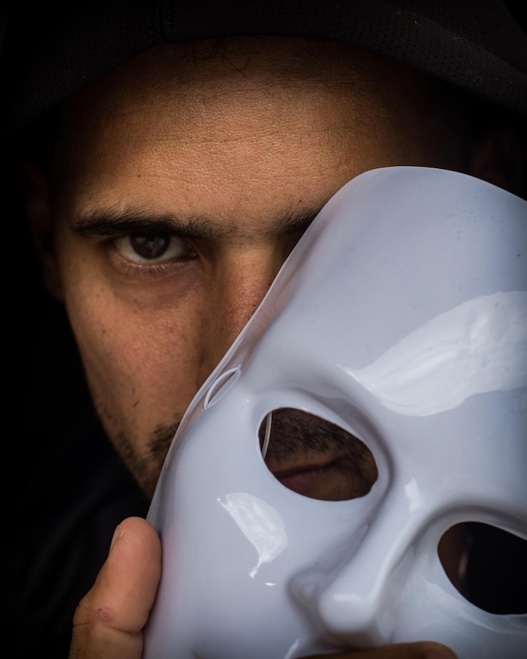 Foto retrato em close-up de um homem segurando uma máscara