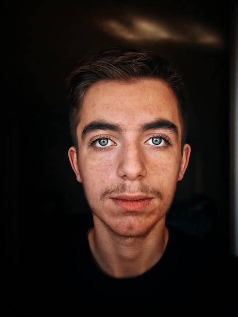 Retrato em close-up de um jovem contra fundo preto