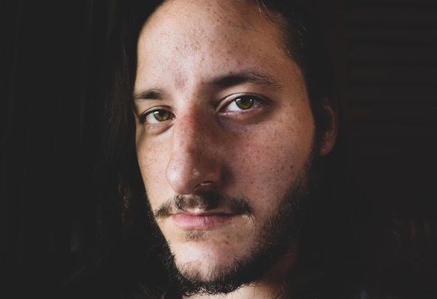 Retrato em close-up de um jovem na sala escura