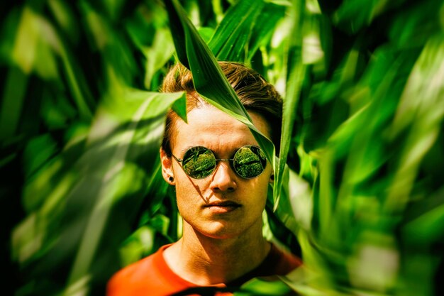 Foto retrato em close-up de um jovem no meio de plantas