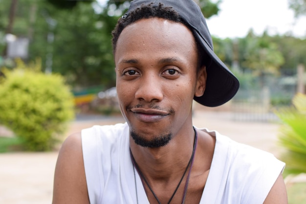 Retrato em close-up de um jovem sorridente usando um boné