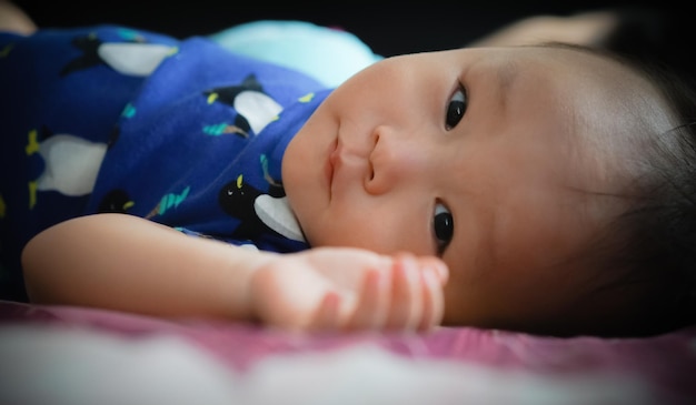 Foto retrato em close-up de um menino bonito deitado em casa