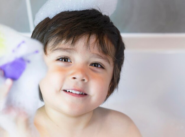 Foto retrato em close-up de um menino bonito e sorridente em casa