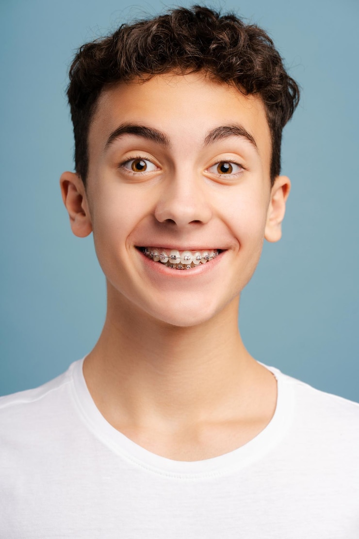 Foto retrato em close-up de um menino surpreso com aparelhos dentários nos dentes olhando para a câmera