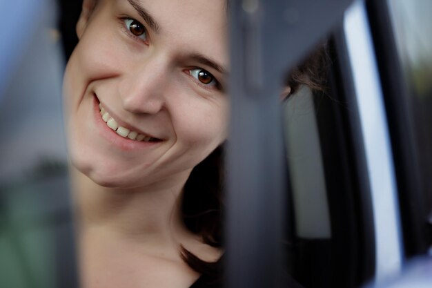 Foto retrato em close-up de um sorridente jovem mulherengo de carro azul