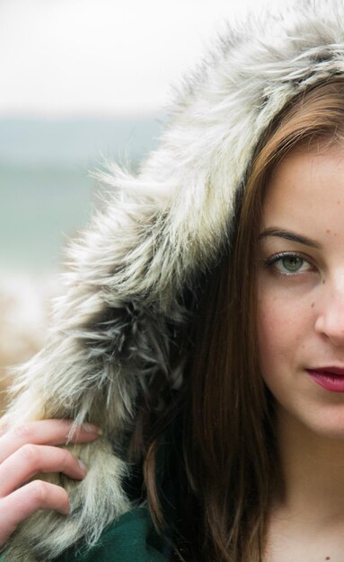 Retrato em close-up de uma bela mulher vestindo um capuz de pele durante o inverno