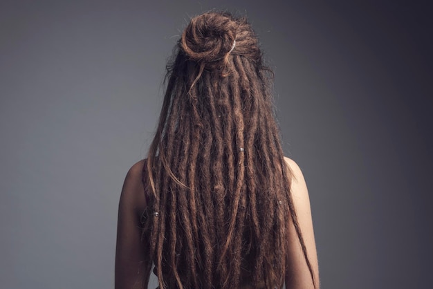 Retrato em close-up de uma jovem com dreadlocks e cabelos longos de costas