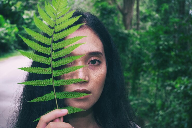 Foto retrato em close-up de uma jovem com folhas verdes