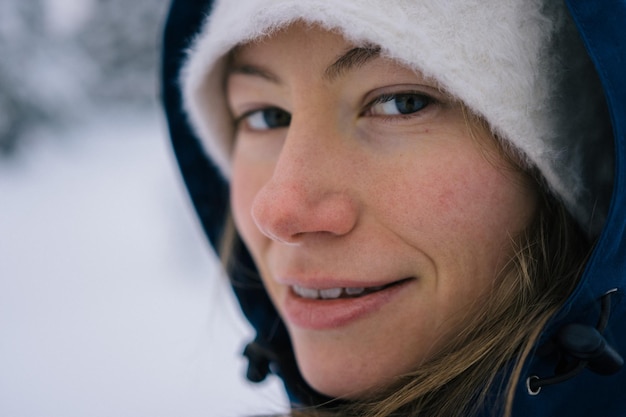 Retrato em close-up de uma jovem de pé em um campo coberto de neve
