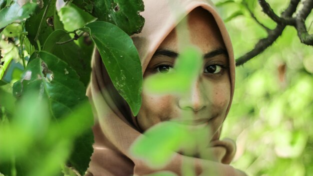 Retrato em close-up de uma jovem junto a árvores