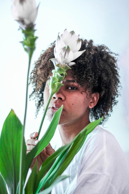 Retrato em close-up de uma jovem por flores brancas